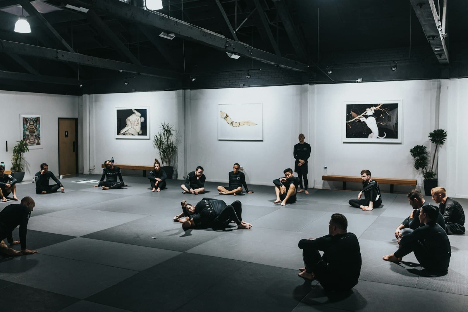 Alumnos sentados sobre el tatami durante una clase de Jiu-Jitsu